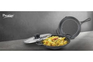 Prestige cast iron cookware featuring a skillet with lid and grill pan, displaying cooked vegetables, showcasing the versatility of cast iron cookware.